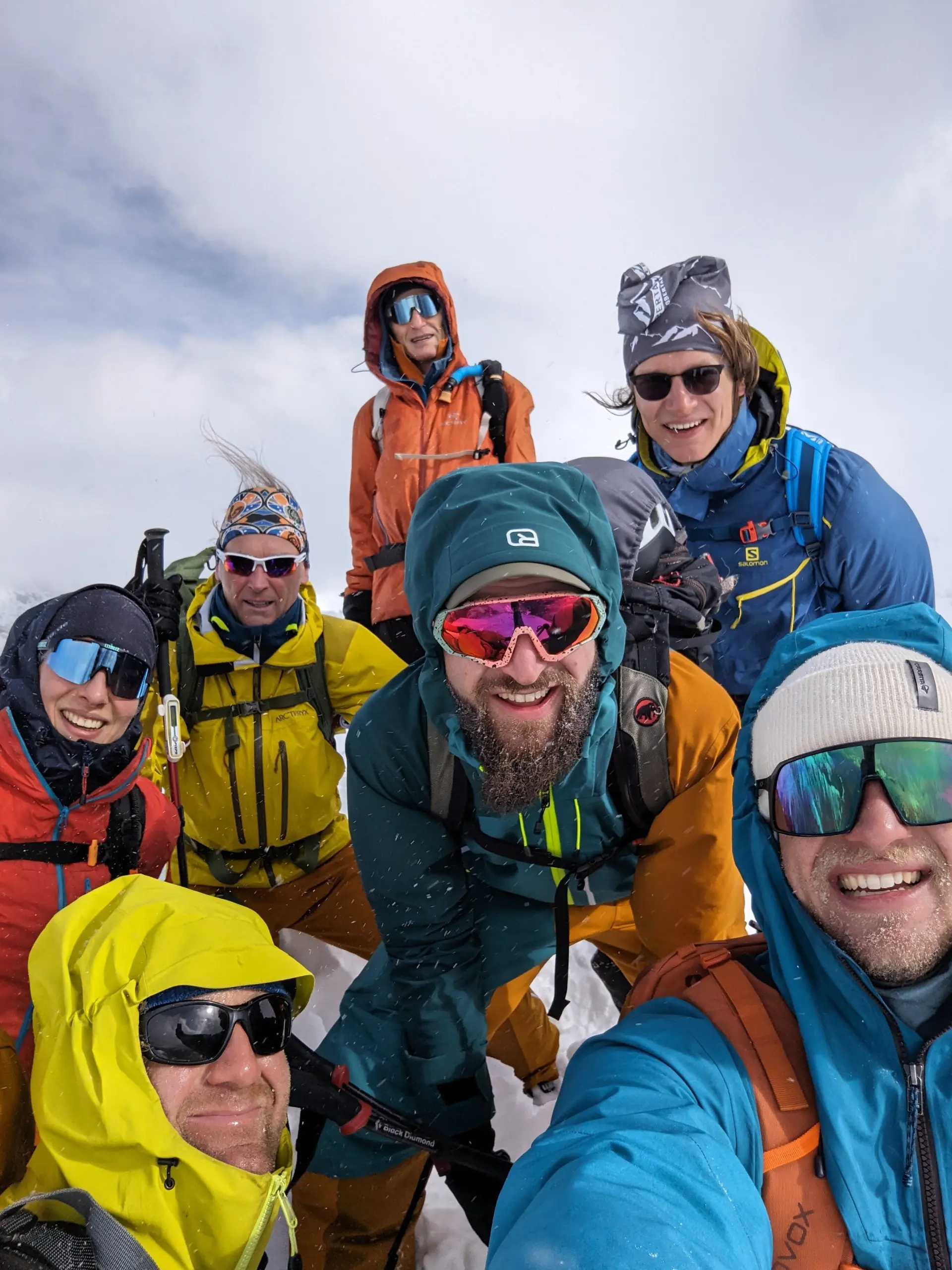 Sieben Personen machen ein Selfie bei windigem Wetter auf dem verschneiten Gipfel. | © DAV Dortmund