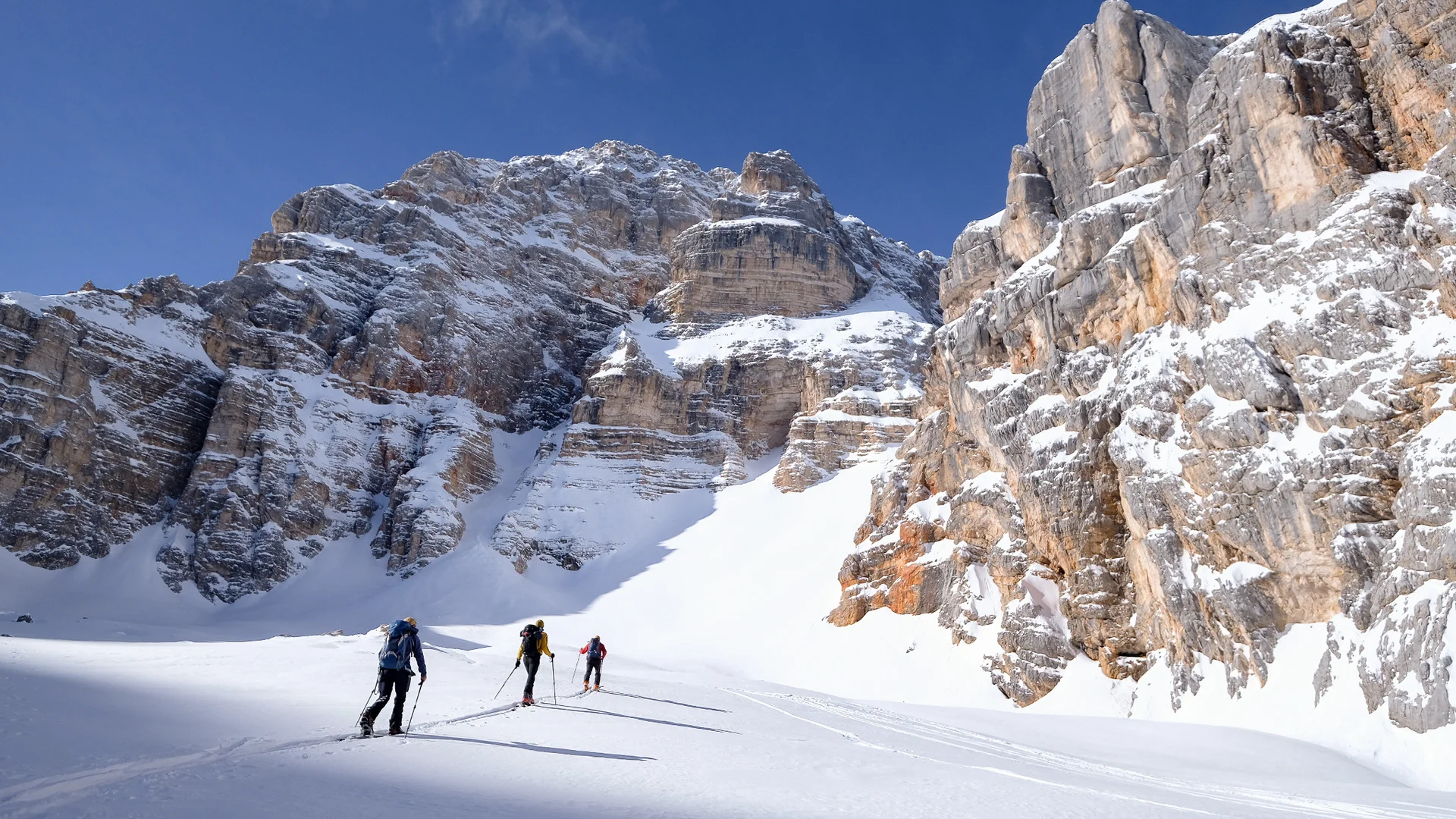 Drei Skitourengeher*innen in Schneelandschaft vor steilen Felswänden | © DAV Dortmund