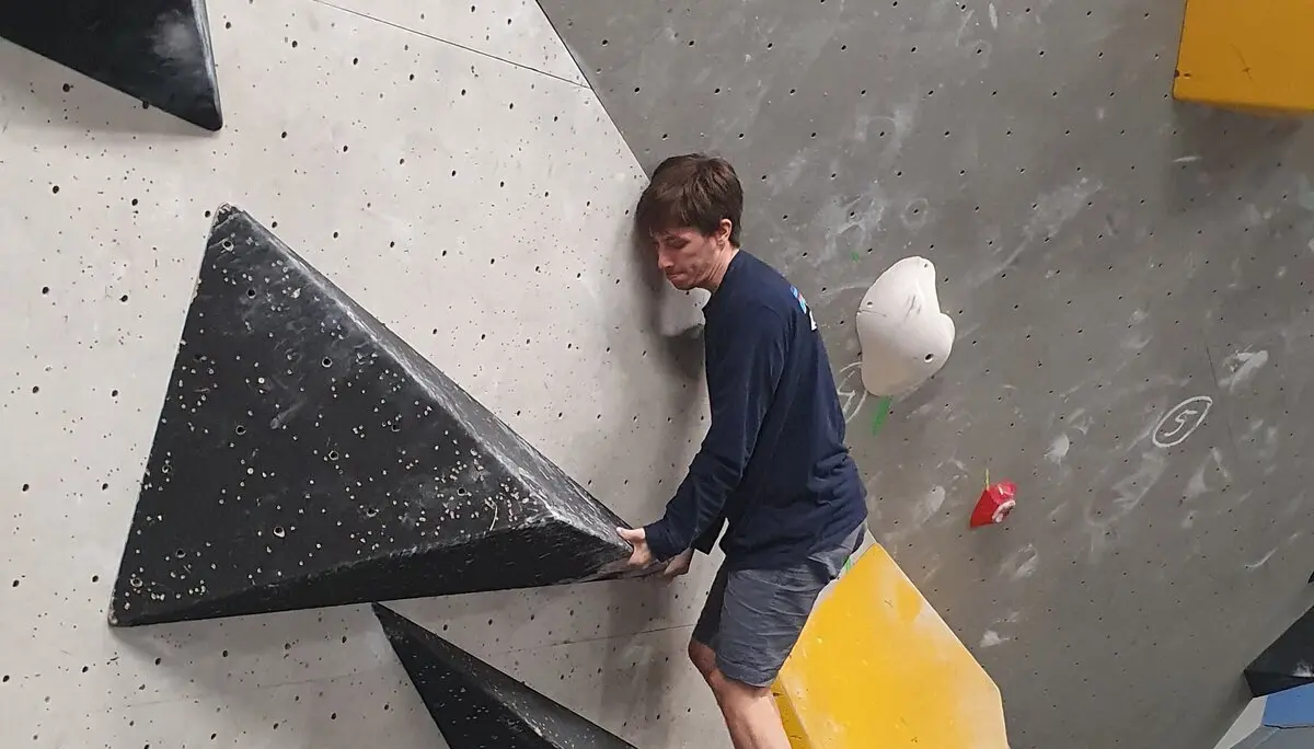 Ein Jugendlicher fokussiert sich auf die Kletterroute an einer Indoor-Boulderwand. | © DAV Dortmund