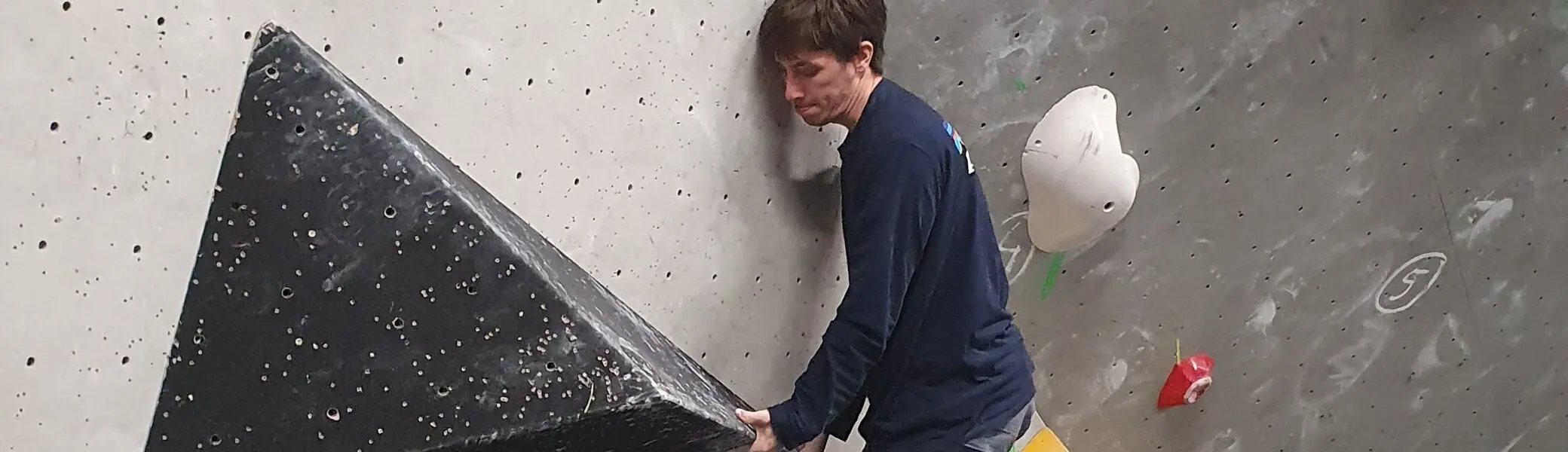 Ein Jugendlicher fokussiert sich auf die Kletterroute an einer Indoor-Boulderwand. | © DAV Dortmund