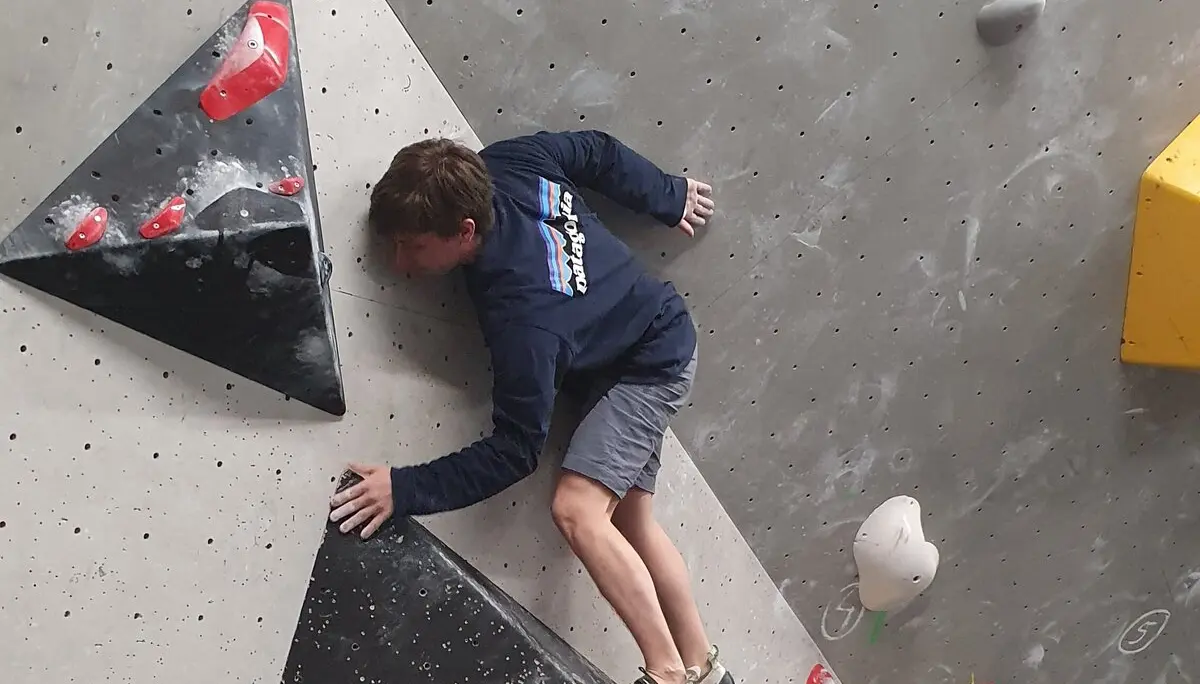 Ein Jugendlicher klettert an einer schwarz-gelben Boulderroute in der Halle. | © DAV Dortmund