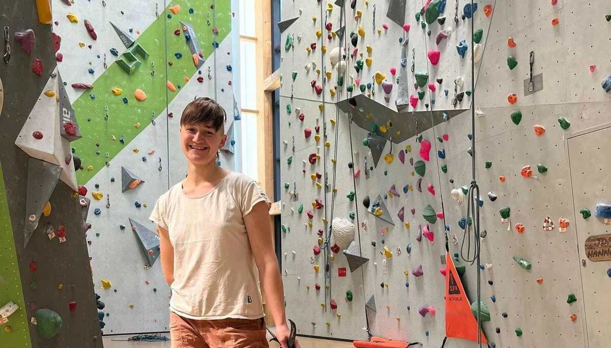 Eine Frau zieht ein großes oranges Seilsack in einer Indoor-Kletterhalle. | © DAV Dortmund