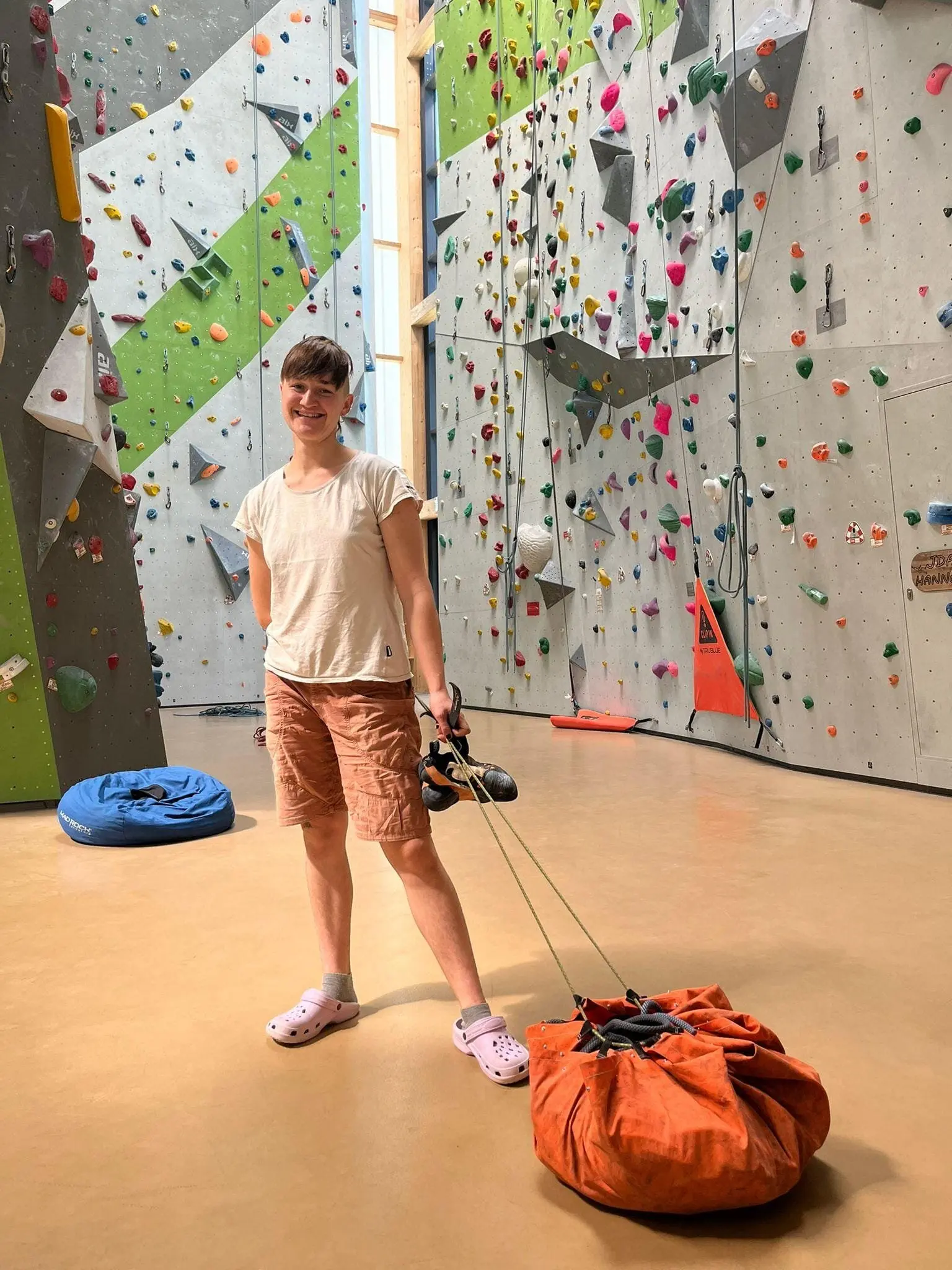 Eine Frau zieht ein großes oranges Seilsack in einer Indoor-Kletterhalle. | © DAV Dortmund