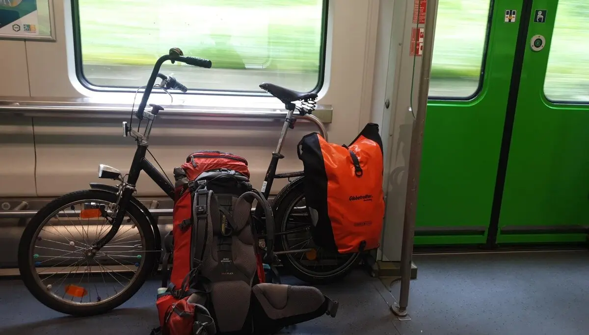 Ein Fahrrad mit zwei großen Rucksäcken steht im Fahrradabteil eines Regionalzugs. | © DAV Dortmund