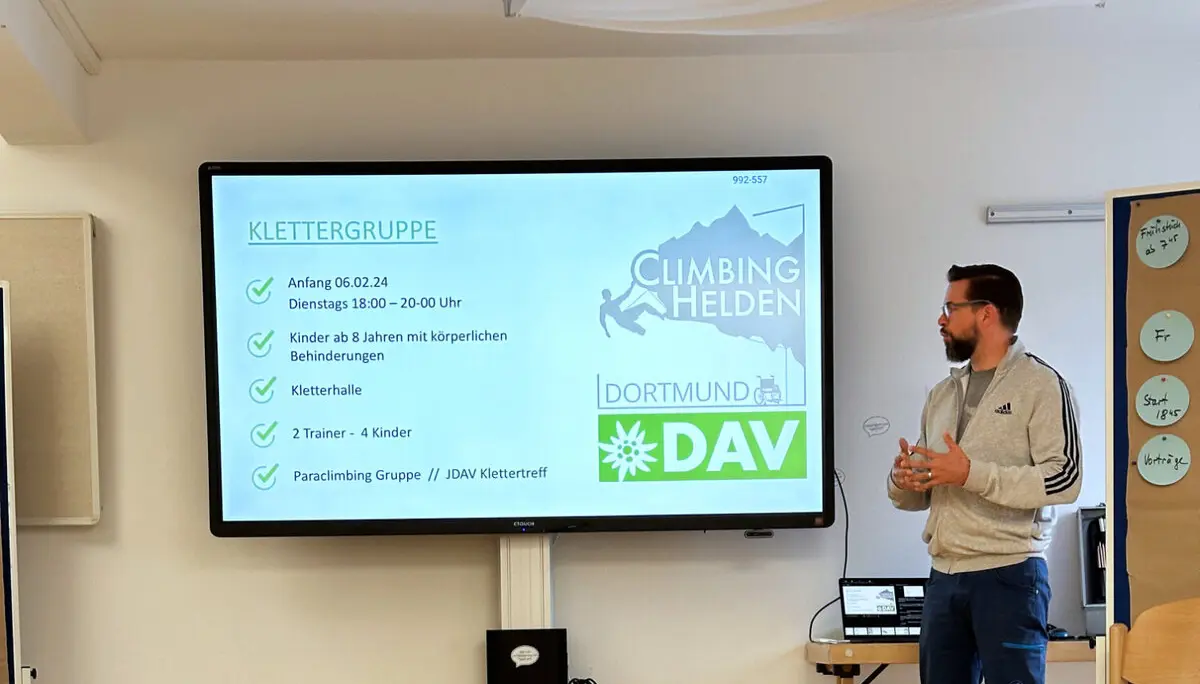 Ein Mann steht vor einer Leinwand mit Präsentation über Sektionsaktivitäten im DAV Dortmund. | © DAV Dortmund