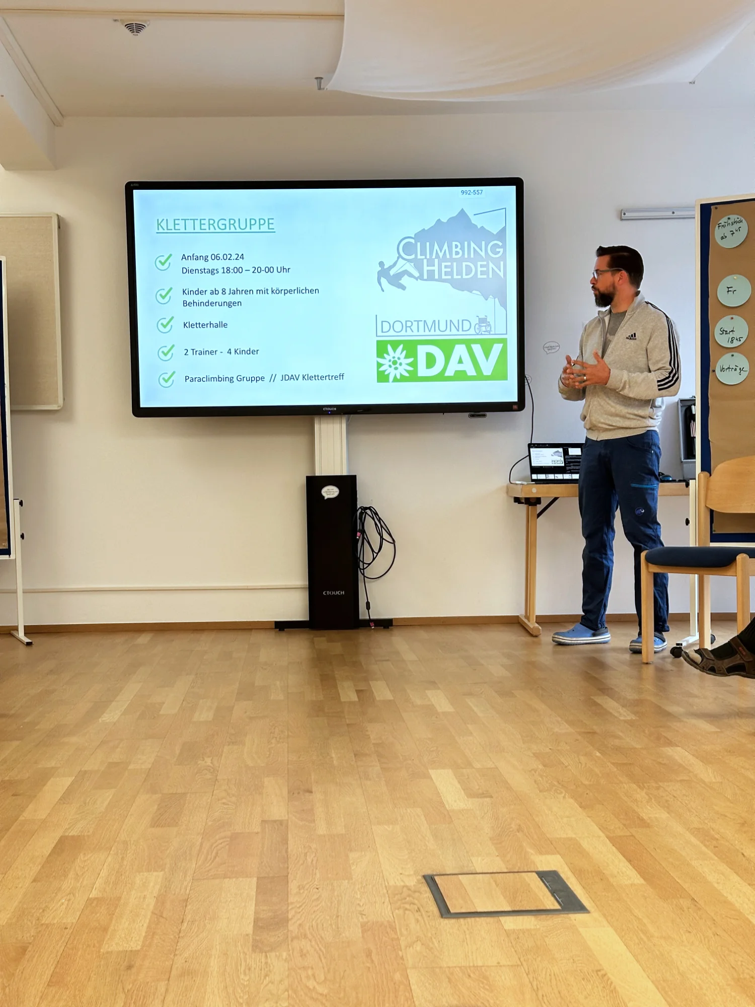 Ein Mann steht vor einer Leinwand mit Präsentation über Sektionsaktivitäten im DAV Dortmund. | © DAV Dortmund