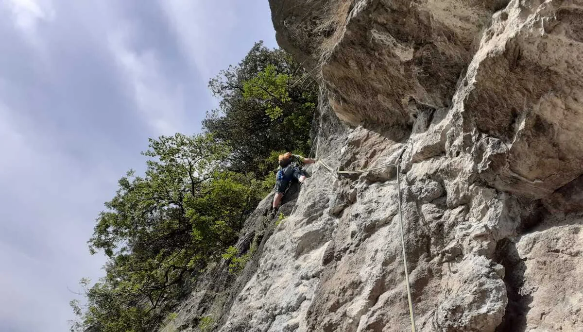 Eine Person klettert mit Seil an einer senkrechten Felswand unter blauem Himmel. | © DAV Dortmund