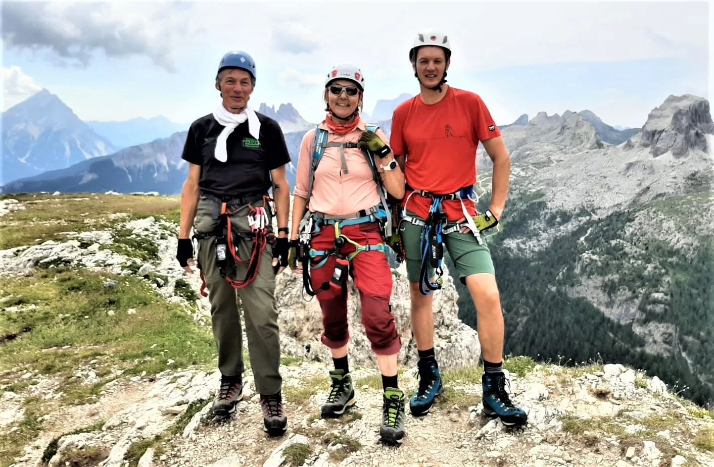 Drei Personen mit Kletterausrüstung stehen auf einem Gipfelplateau mit Blick auf umliegende Berge. | © DAV Dortmund