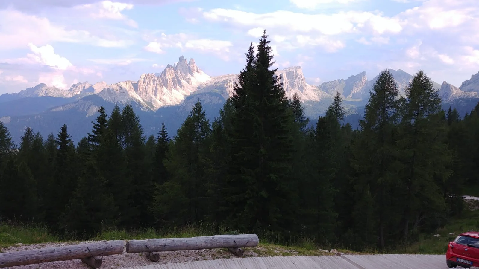 Panoramaaufnahme der Dolomiten mit bewaldetem Vordergrund und hellen Bergspitzen im Abendlicht. | © DAV Dortmund
