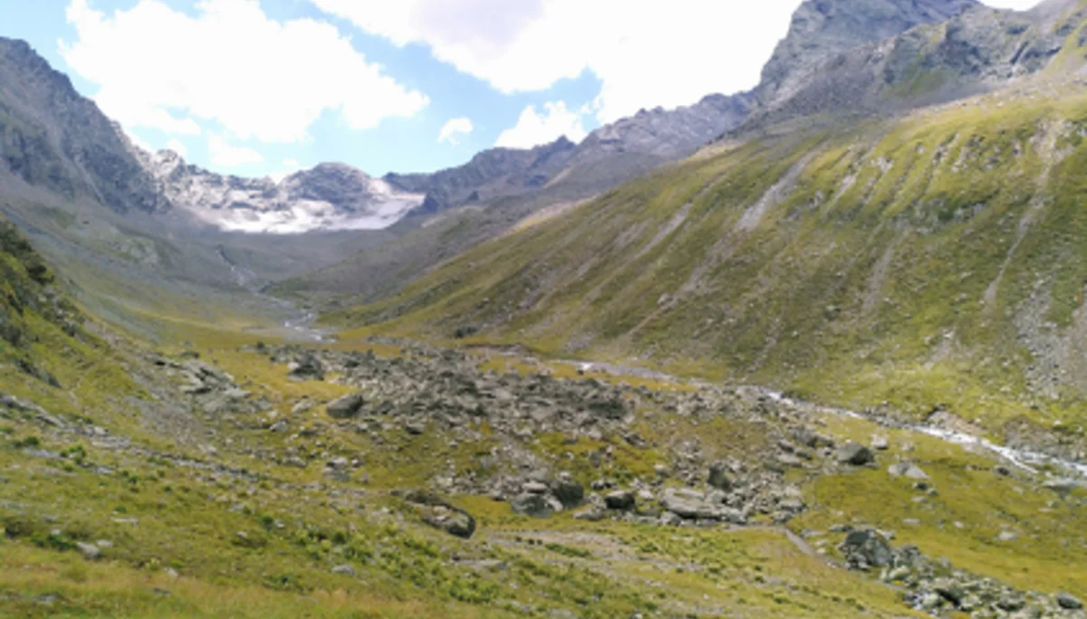 Blick in ein grünes, weites Gebirgstal mit Felsen, Wiesen und einem Gletscher im Hintergrund. | © DAV Dortmund