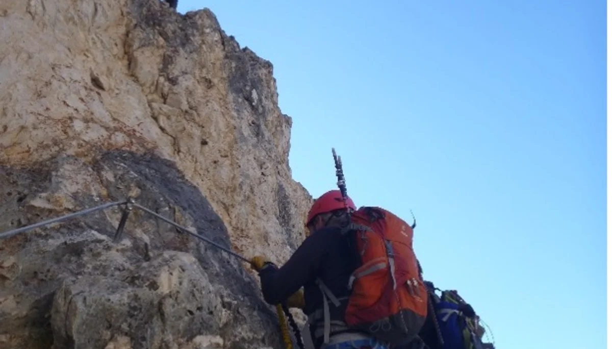 Zwei Personen klettern mit Klettersteigset an einer steilen Felswand im Gegenlicht. | © DAV Dortmund