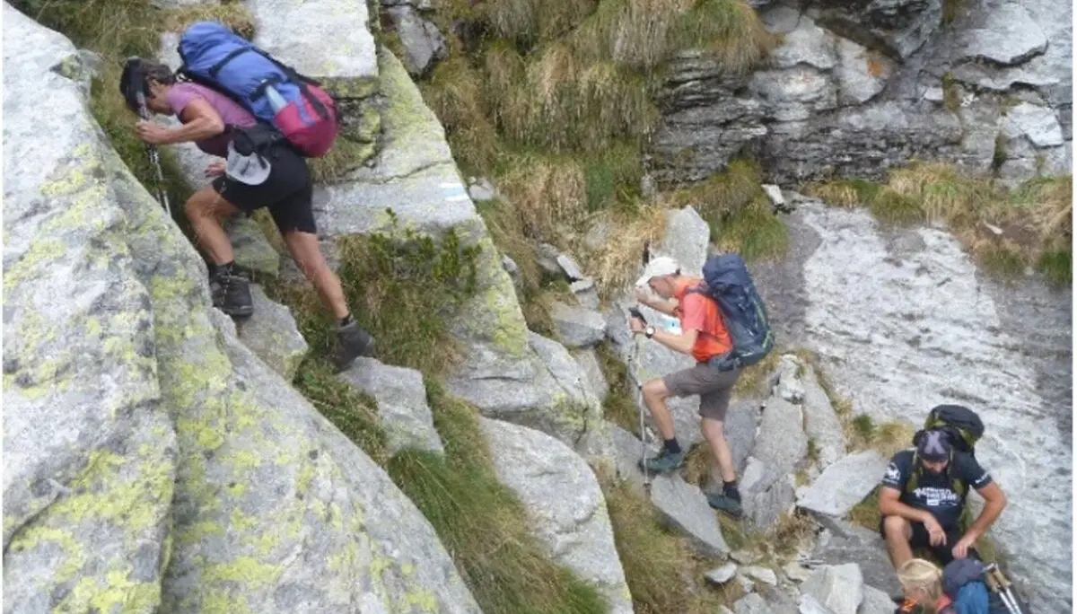 Vier Personen steigen mit Rucksäcken durch felsiges Gelände auf einem steilen Pfad. | © DAV Dortmund