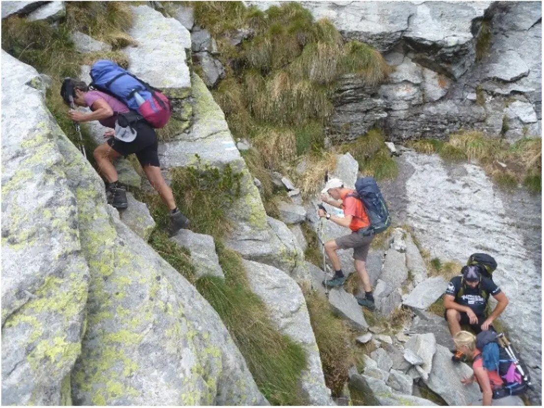 Vier Personen steigen mit Rucksäcken durch felsiges Gelände auf einem steilen Pfad. | © DAV Dortmund