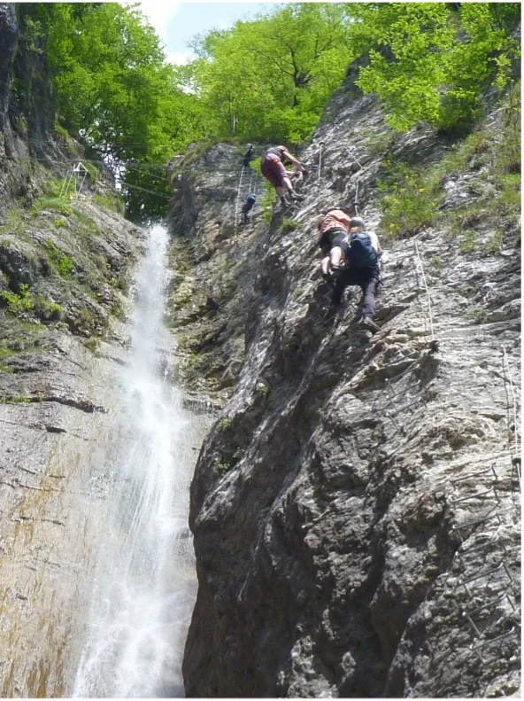  Zwei Kletternde bewegen sich auf einem Klettersteig neben einem schmalen Wasserfall. | © DAV Dortmund