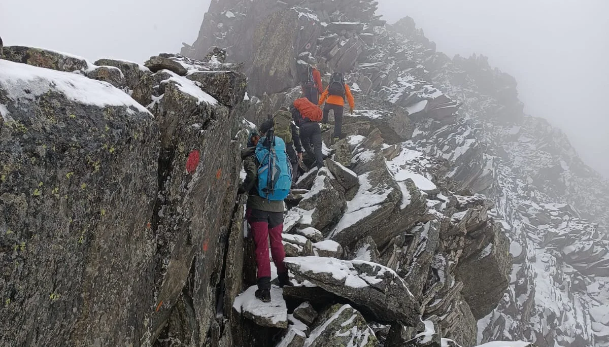 Mehrere Personen steigen über einen schmalen, verschneiten Felsgrat bei Nebel und Kälte. | © DAV Dortmund