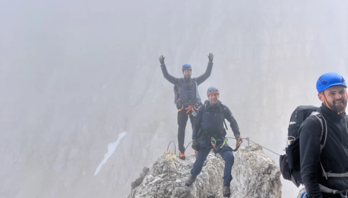 Drei Personen stehen auf einem schmalen, felsigen Grat mit Nebel im Hintergrund. | © DAV Dortmund