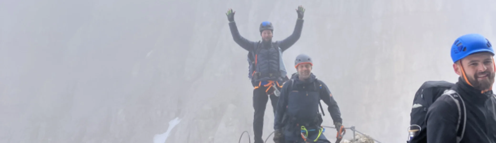 Drei Personen stehen auf einem schmalen, felsigen Grat mit Nebel im Hintergrund. | © DAV Dortmund