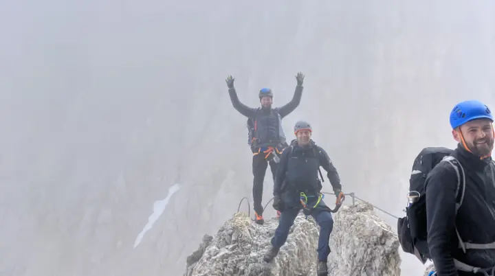 Drei Personen stehen auf einem schmalen, felsigen Grat mit Nebel im Hintergrund. | © DAV Dortmund