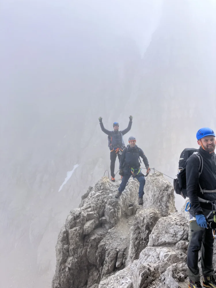 Drei Personen stehen auf einem schmalen, felsigen Grat mit Nebel im Hintergrund. | © DAV Dortmund