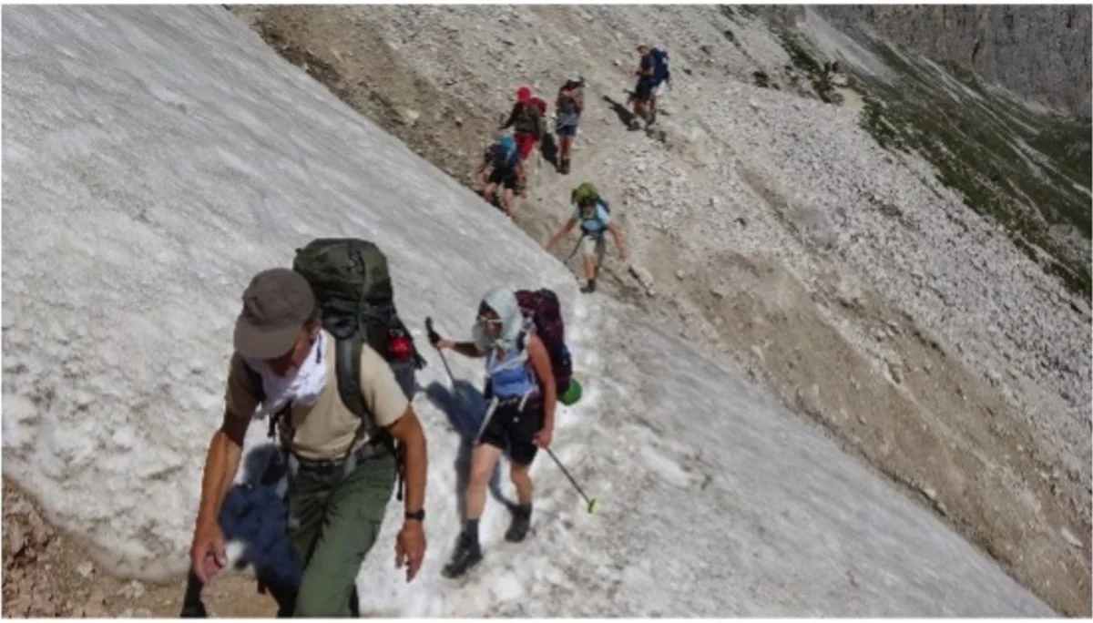Gruppe von Wanderern quert ein Schneefeld auf einem Berghang, mit Rucksäcken ausgerüstet. | © DAV Dortmund