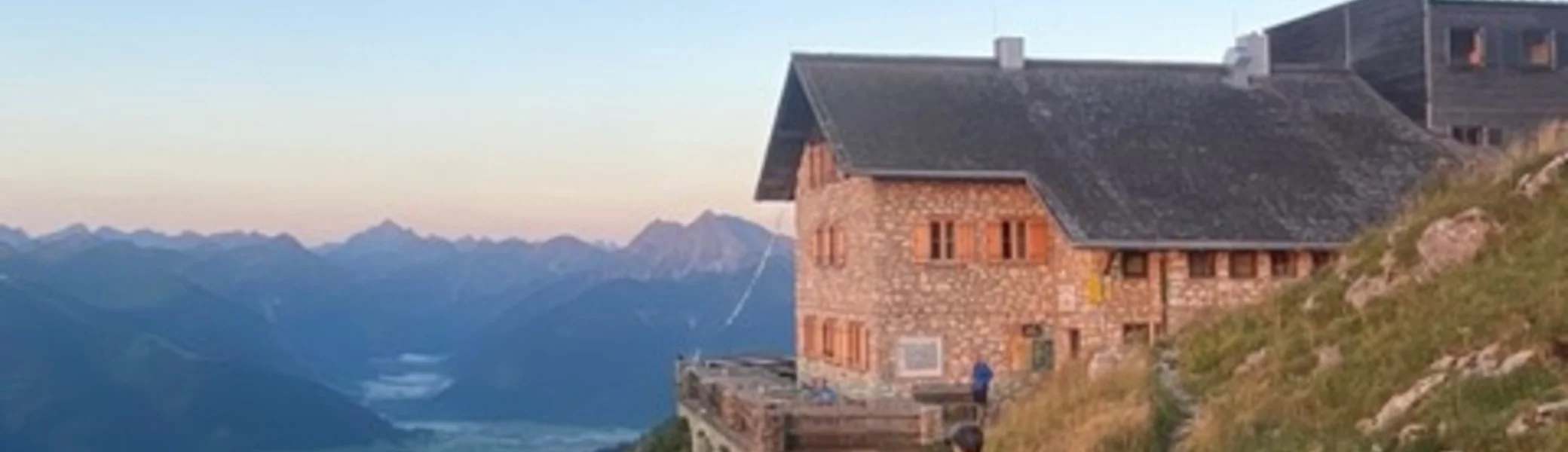 Eine Hütte im Morgenlicht mit weitem Blick über das Tal und die Berge. | © KD Schüler 