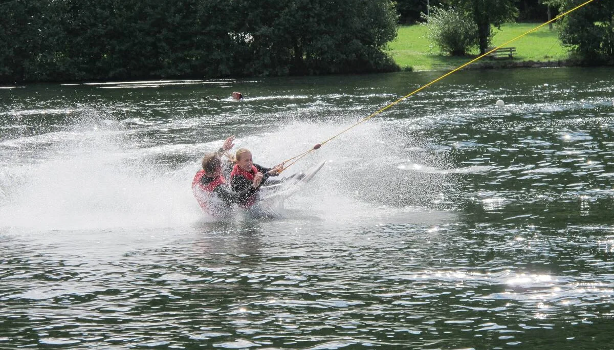 Zwei Personen fallen gemeinsam beim Wasserskifahren ins Wasser. | © DAV Dortmund