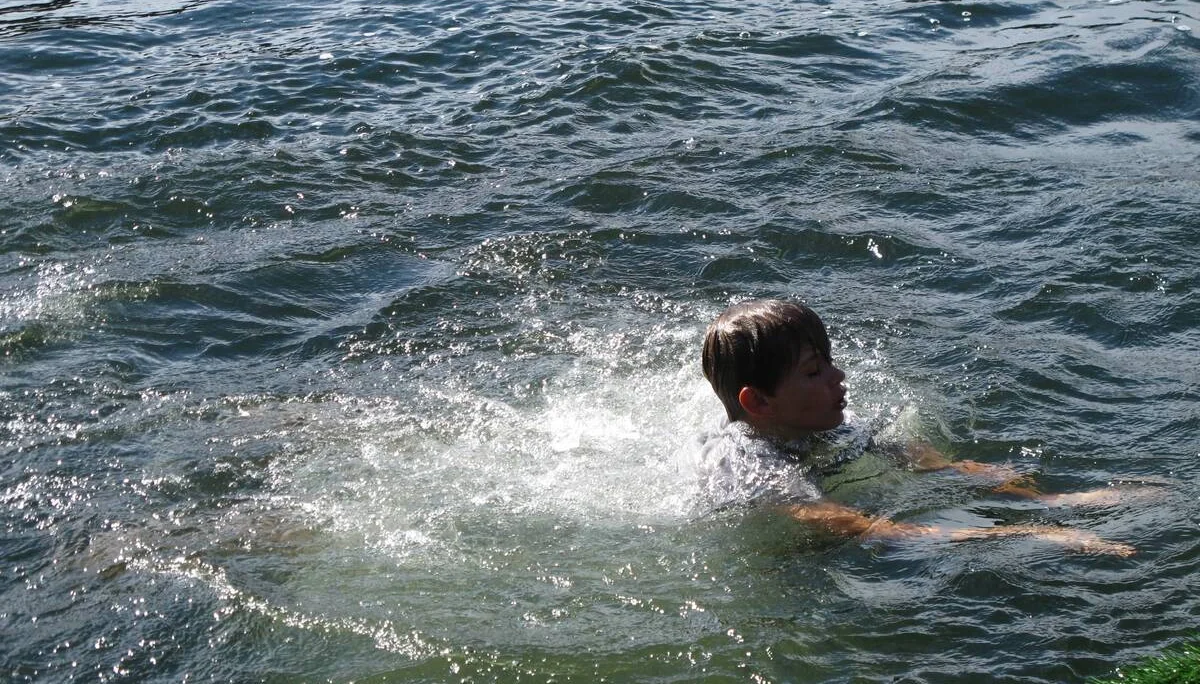 Ein Kind schwimmt Richtung Ufer, Wasser spritzt um ihn herum. | © DAV Dortmund