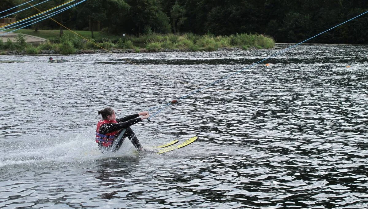 Eine Person fährt mit Wasserskiern über einen See und wird von einem Seil gezogen. | © DAV Dortmund