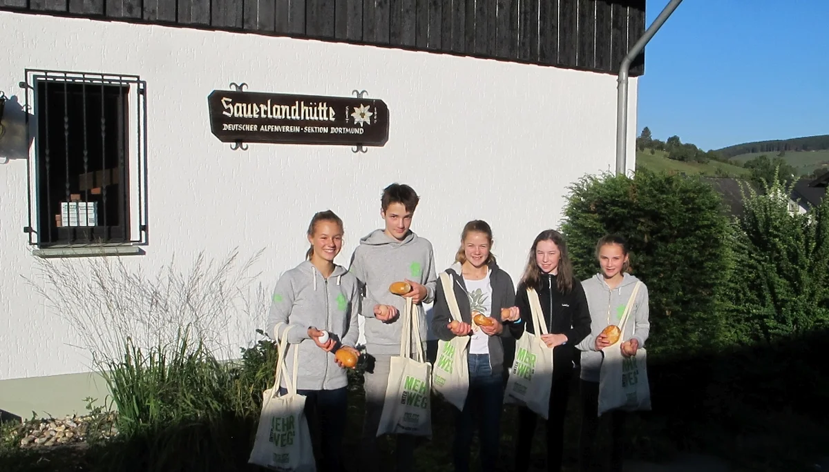 Fünf Jugendliche stehen vor einem Gebäude mit Brötchen und Mehrwegtaschen in der Hand. | © DAV Dortmund