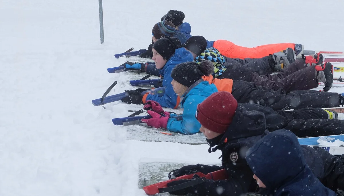 Mehrere Kinder liegen nebeneinander im Schnee und schießen mit Biathlon-Gewehren. | © DAV Dortmund