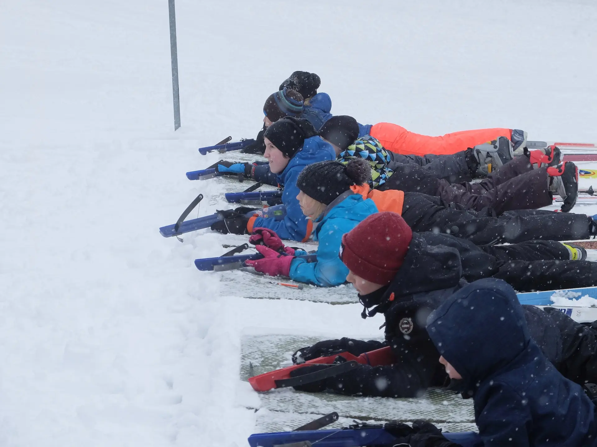 Mehrere Kinder liegen nebeneinander im Schnee und schießen mit Biathlon-Gewehren. | © DAV Dortmund