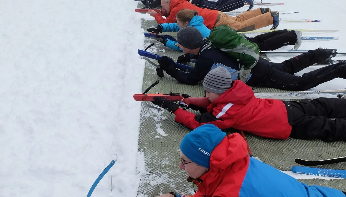Kinder liegen auf Matten im Schnee und zielen mit Biathlon-Gewehren auf eine Zielscheibe. | © DAV Dortmund