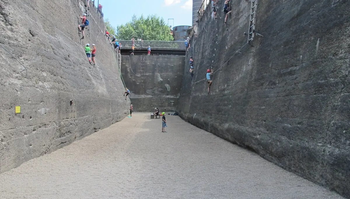 Mehrere Personen klettern an den hohen Wänden eines trockengelegten Beckens. | © DAV Dortmund