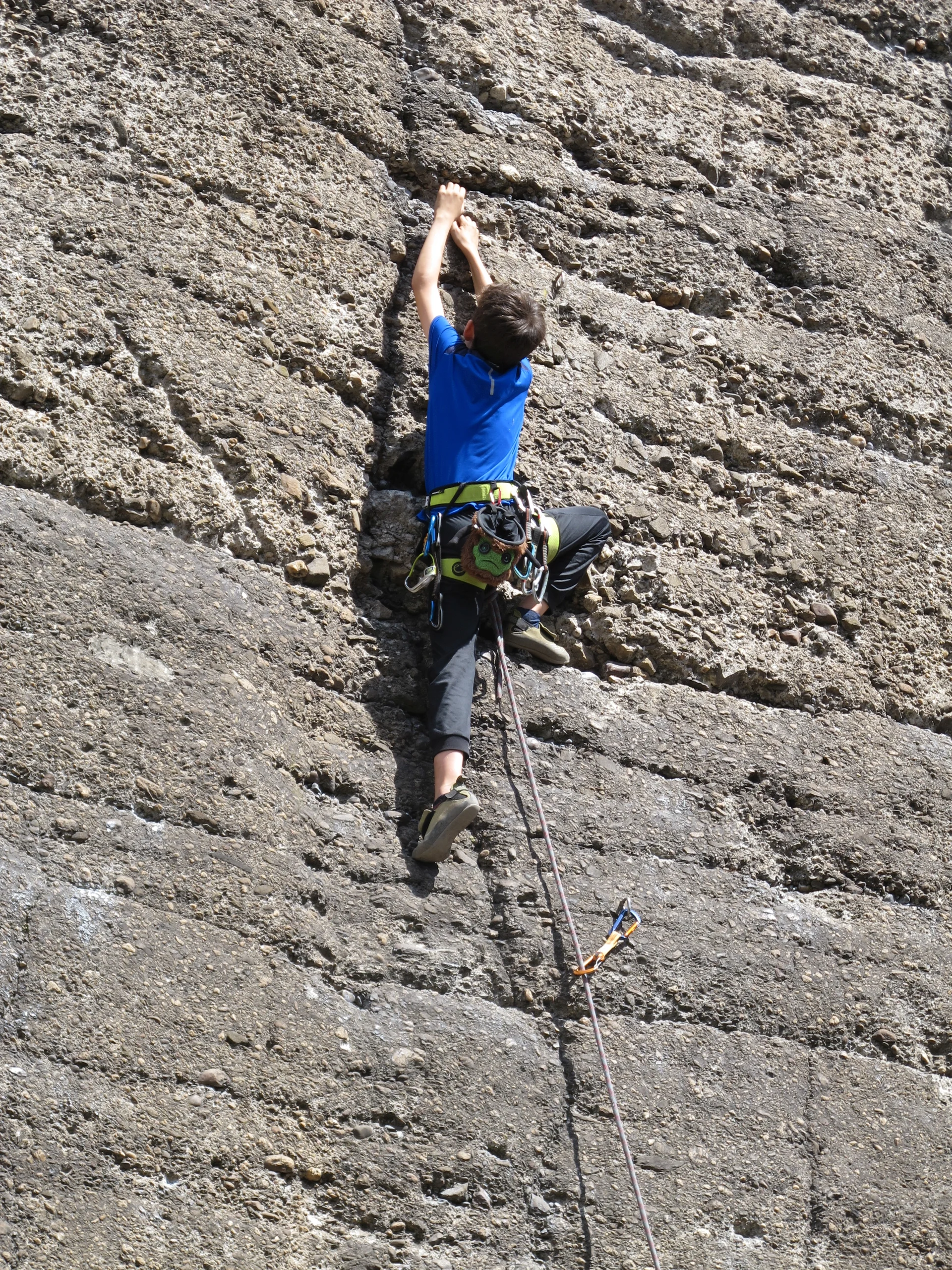 Ein Junge mit Klettergurt erklimmt konzentriert eine künstliche Kletterwand. | © DAV Dortmund