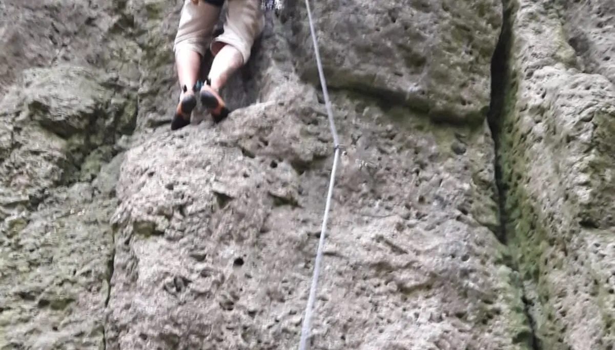 Person mit Kletterausrüstung klettert eine senkrechte Felswand hoch. | © DAV Dortmund