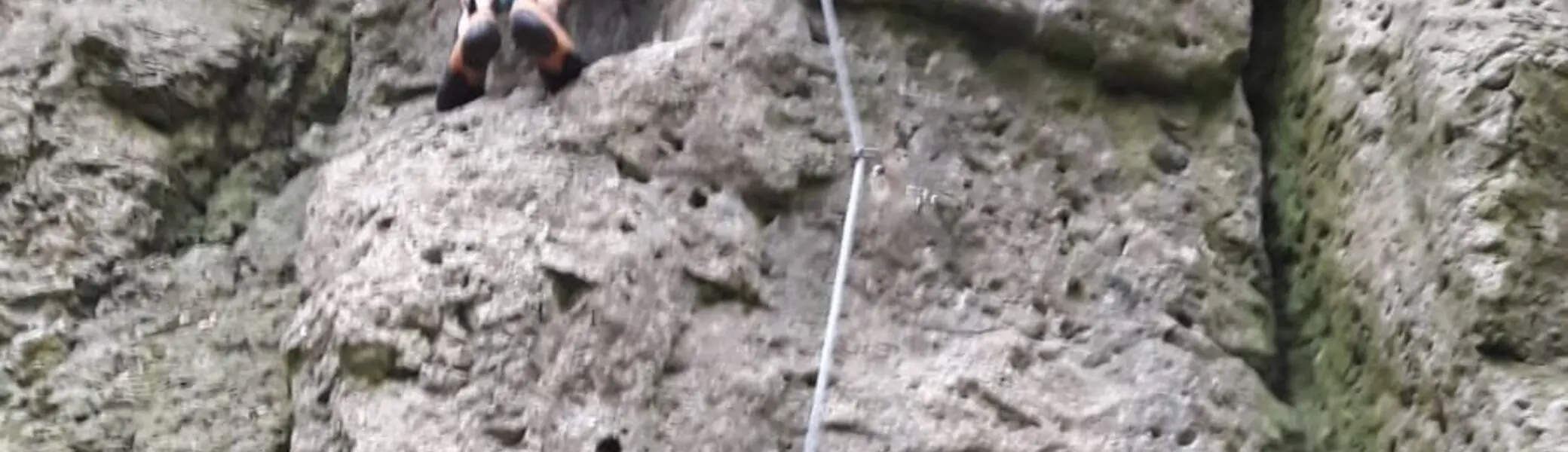 Person mit Kletterausrüstung klettert eine senkrechte Felswand hoch. | © DAV Dortmund