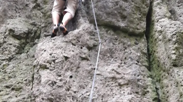 Person mit Kletterausrüstung klettert eine senkrechte Felswand hoch. | © DAV Dortmund