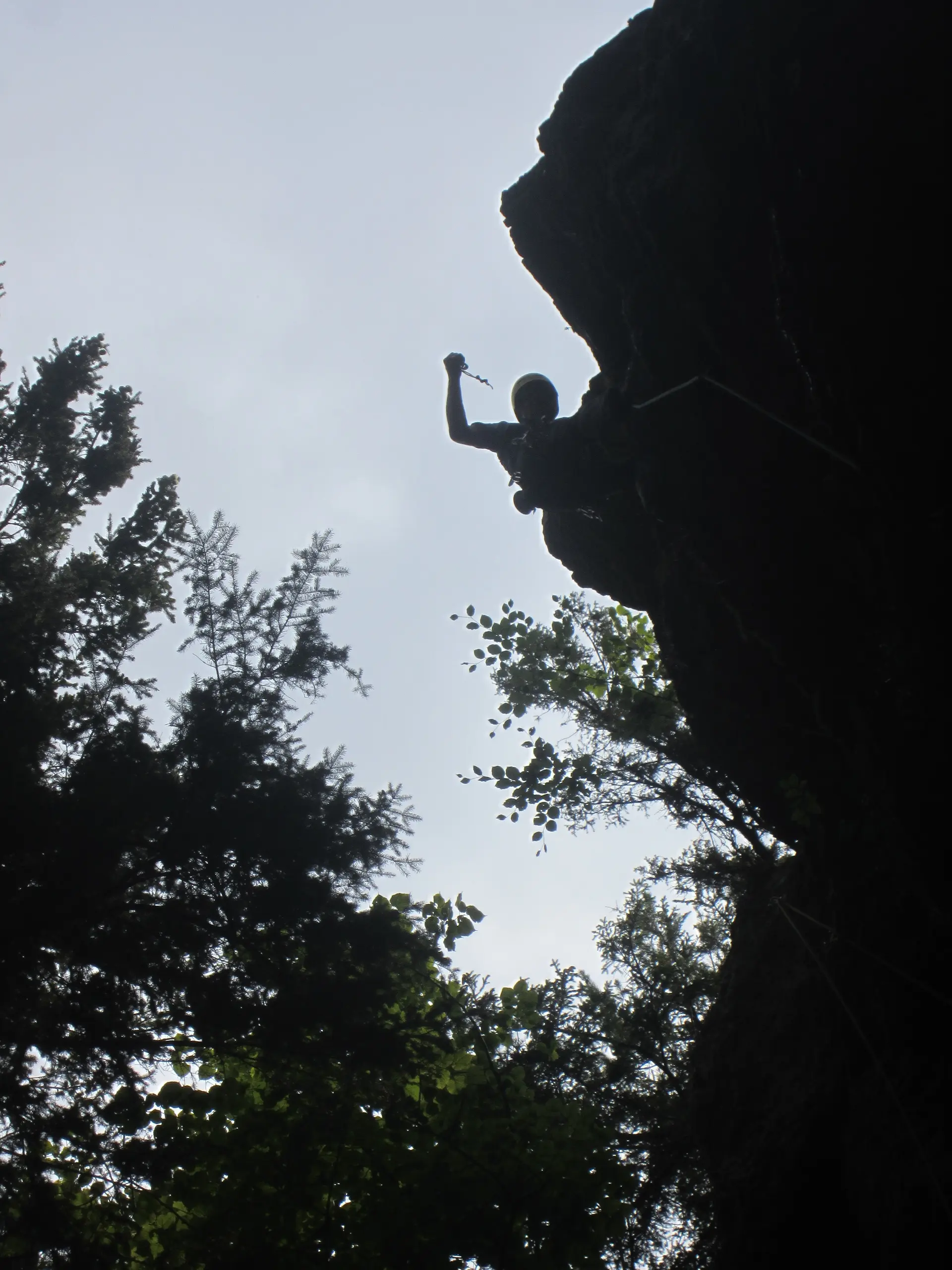 Silhouette eines Kletterers am Überhang mit erhobenem Arm. | © DAV Dortmund