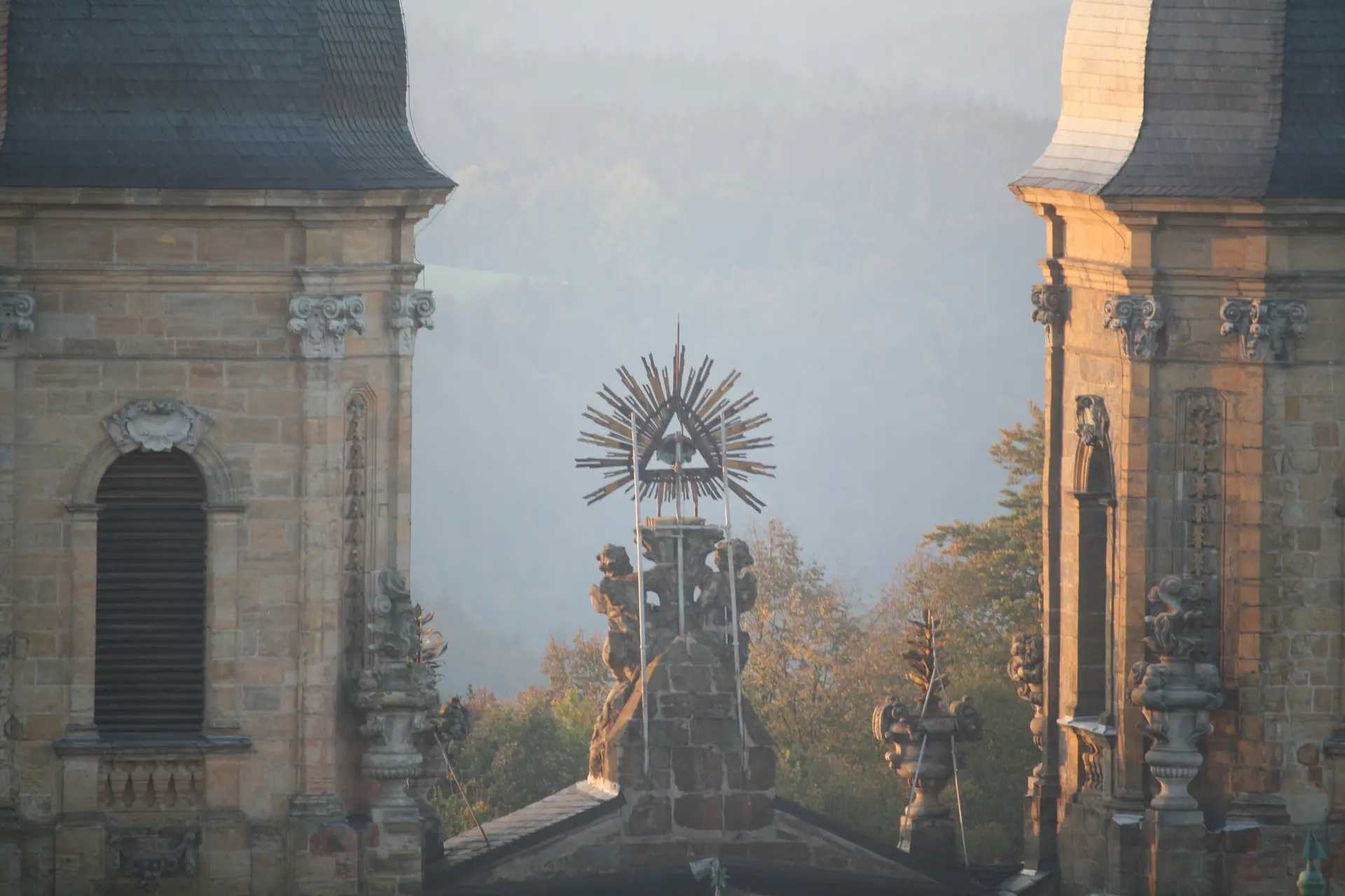 Blick auf zwei Türme eines Klosters mit einer leuchtenden Strahlensonne dazwischen im Morgenlicht. | © DAV Dortmund