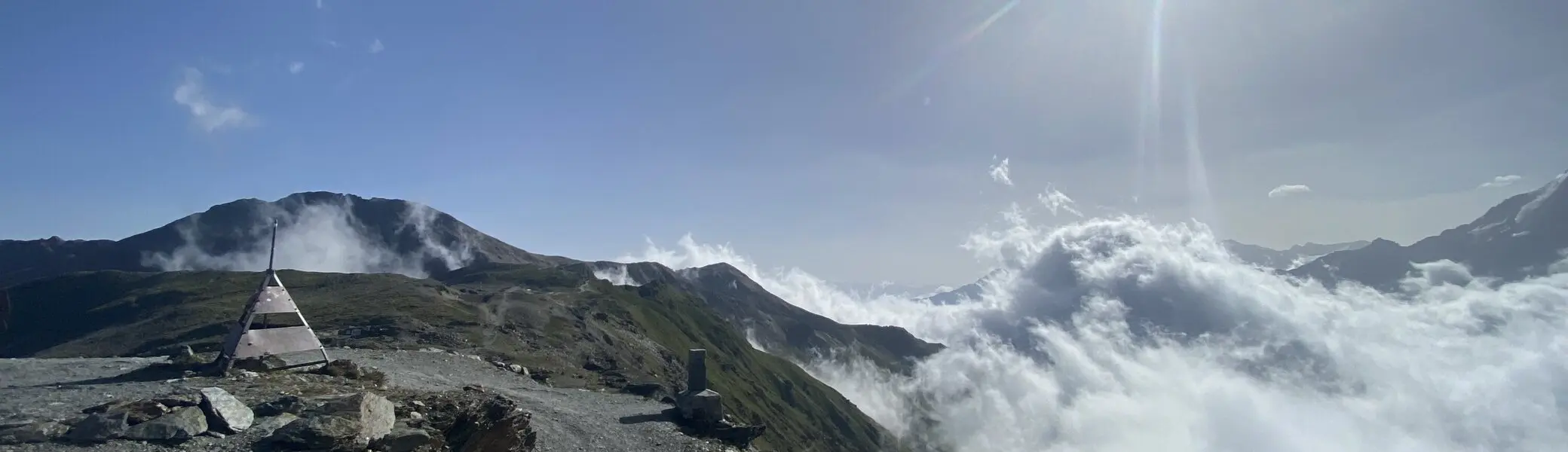 Ein schmaler Bergpfad führt über einen Grat, umgeben von Wolkenmeer und strahlender Sonne. | © DAV Dortmund