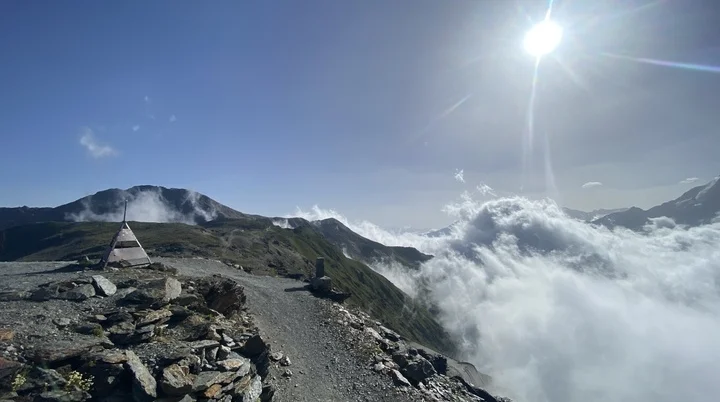 Ein schmaler Bergpfad führt über einen Grat, umgeben von Wolkenmeer und strahlender Sonne. | © DAV Dortmund