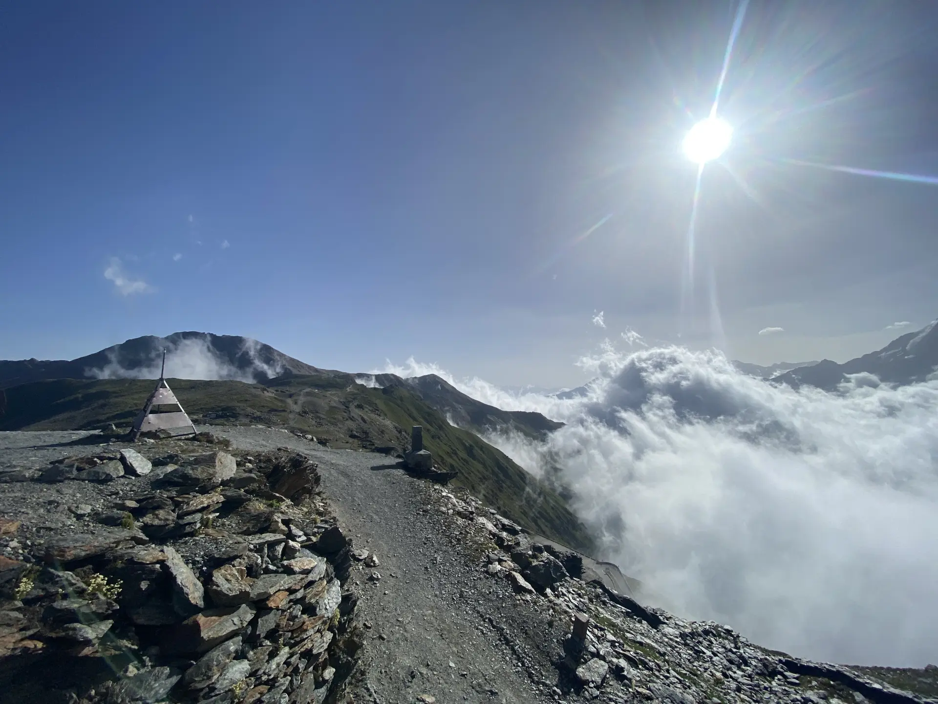 Ein schmaler Bergpfad führt über einen Grat, umgeben von Wolkenmeer und strahlender Sonne. | © DAV Dortmund