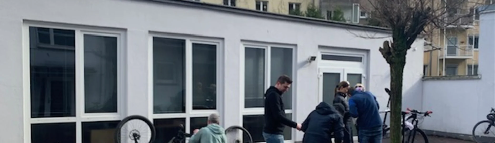 Mehrere Personen reparieren Fahrräder im Innenhof eines Gebäudes. | © DAV Dortmund