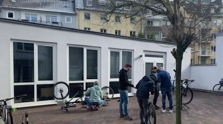 Mehrere Personen reparieren Fahrräder im Innenhof eines Gebäudes. | © DAV Dortmund