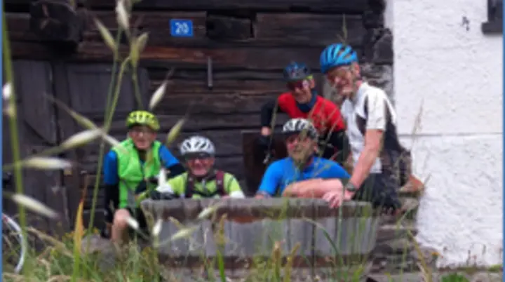 Gruppe von Rennradfahrer*innen macht Pause vor einem alten Gebäude im Grünen. | © DAV Dortmund