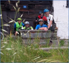 Gruppe von Rennradfahrer*innen macht Pause vor einem alten Gebäude im Grünen. | © DAV Dortmund