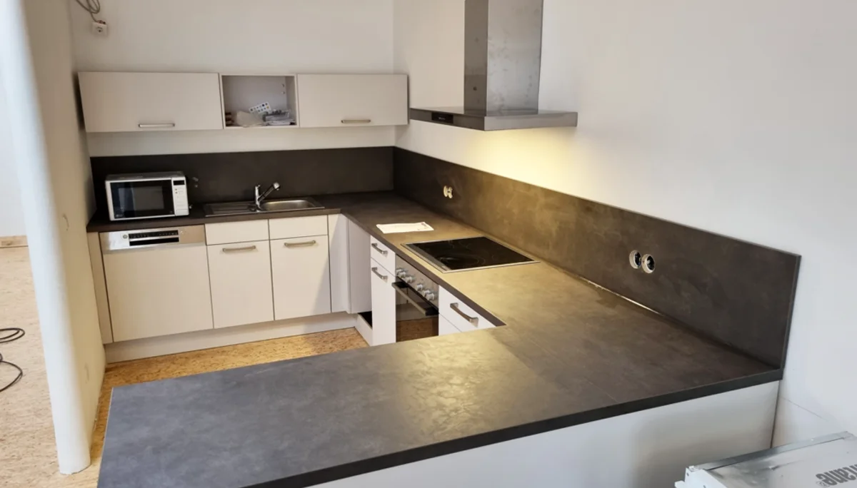 Moderne Einbauküche mit Herd, Mikrowelle und dunkler Arbeitsplatte. | © DAV Dortmund