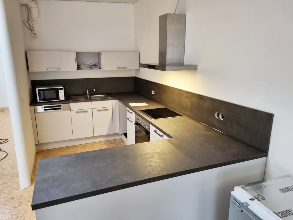 Moderne Einbauküche mit Herd, Mikrowelle und dunkler Arbeitsplatte. | © DAV Dortmund