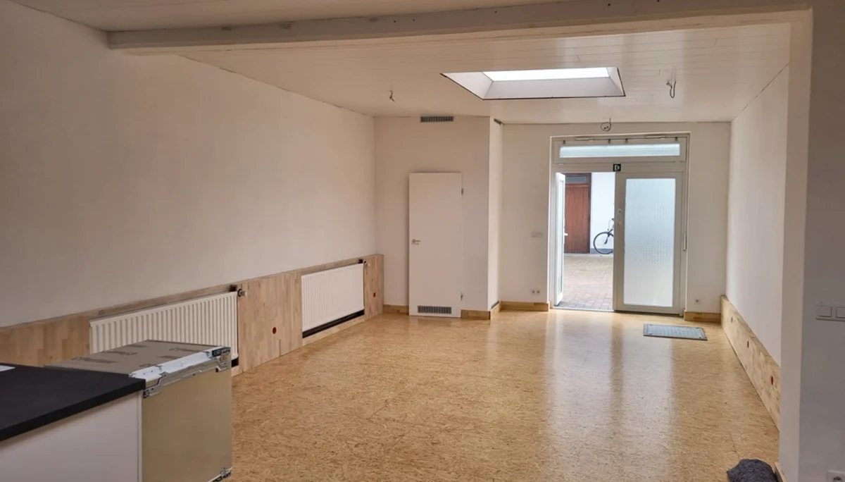 Blick in einen leeren, frisch renovierten Gruppenraum mit Tür zur Terrasse. | © DAV Dortmund