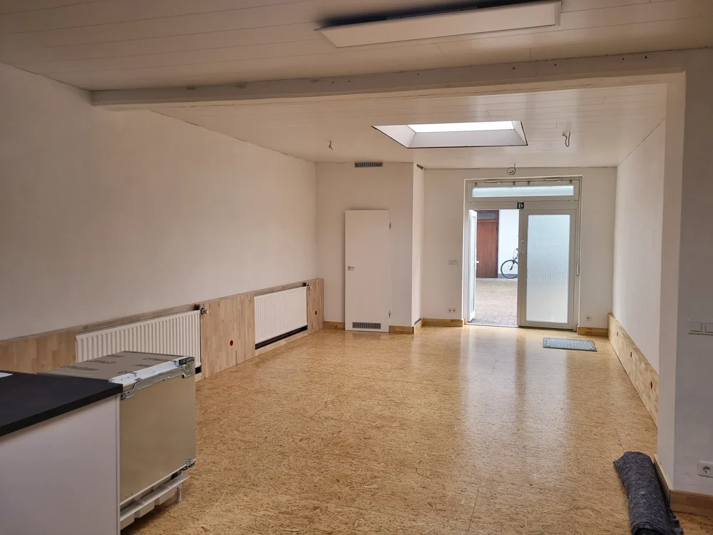 Blick in einen leeren, frisch renovierten Gruppenraum mit Tür zur Terrasse. | © DAV Dortmund